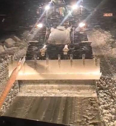 Karlı yolda mahsur kalan tır, iş makinesiyle kurtarıldı