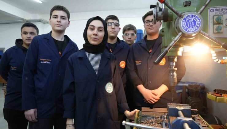 Kadın öğretmen torna tezgahında öğrencilerine üretimi öğretiyor